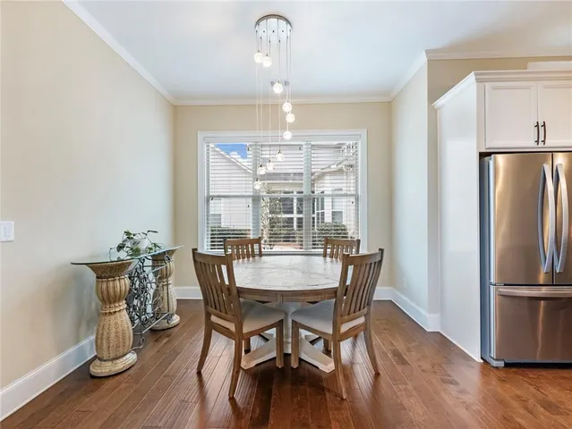 a bedroom with a large bed a flat tv screen and a chandelier