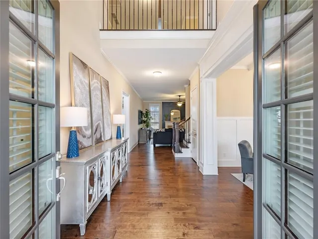 a view of a hallway with wooden floor and stairs