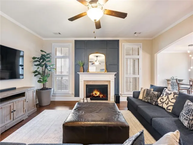 a kitchen with stainless steel appliances kitchen island granite countertop a dining table chairs stove and white cabinets