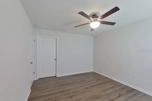 a view of an empty room with wooden floor