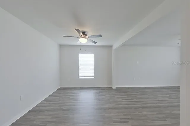a view of a room with wooden floor and window