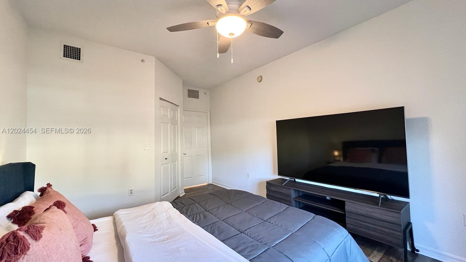 2727 Anzio Court, Unit 106 Palm Beach Gardens, FL 33410 - Photo 21 of 43 a bedroom with a bed and a flat screen tv