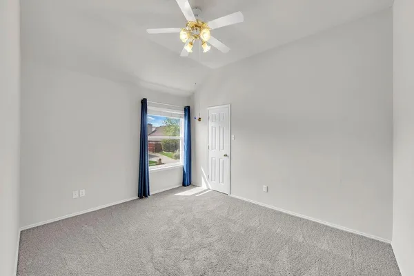 an empty room with fan and entrance