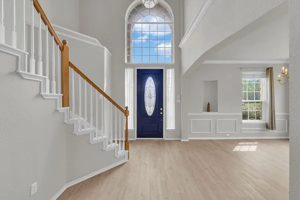 a view of an entryway with wooden floor door and a living room