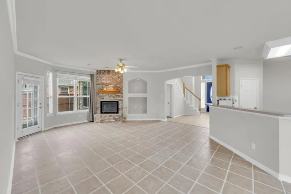 an empty room with fireplace and windows