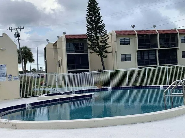 a front view of a house with swimming pool having outdoor seating