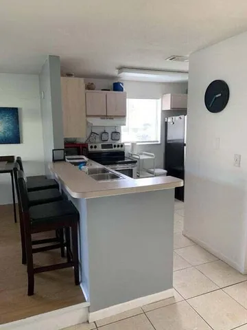 a kitchen with stainless steel appliances a stove a sink a microwave and a refrigerator