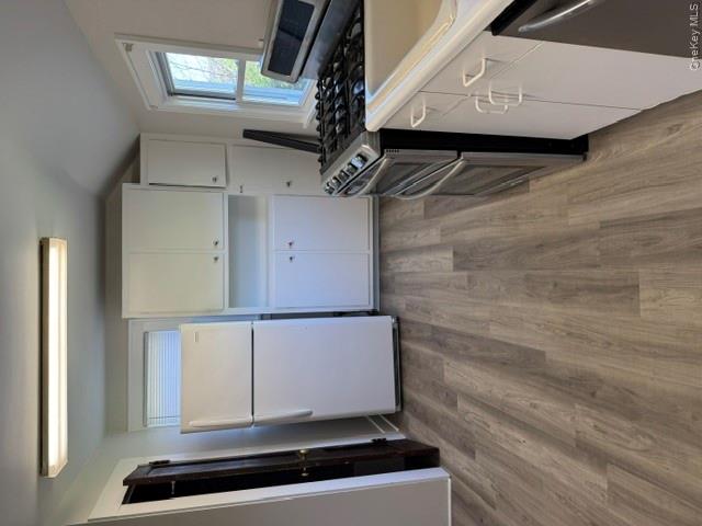 95 Upper Wisner Road Warwick, NY 10990 - Photo 8 of 14 a kitchen with wooden floors and white appliances