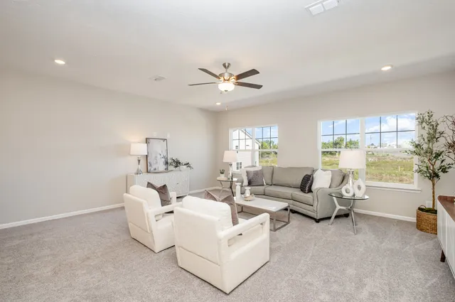a living room with furniture and a large window with garden view