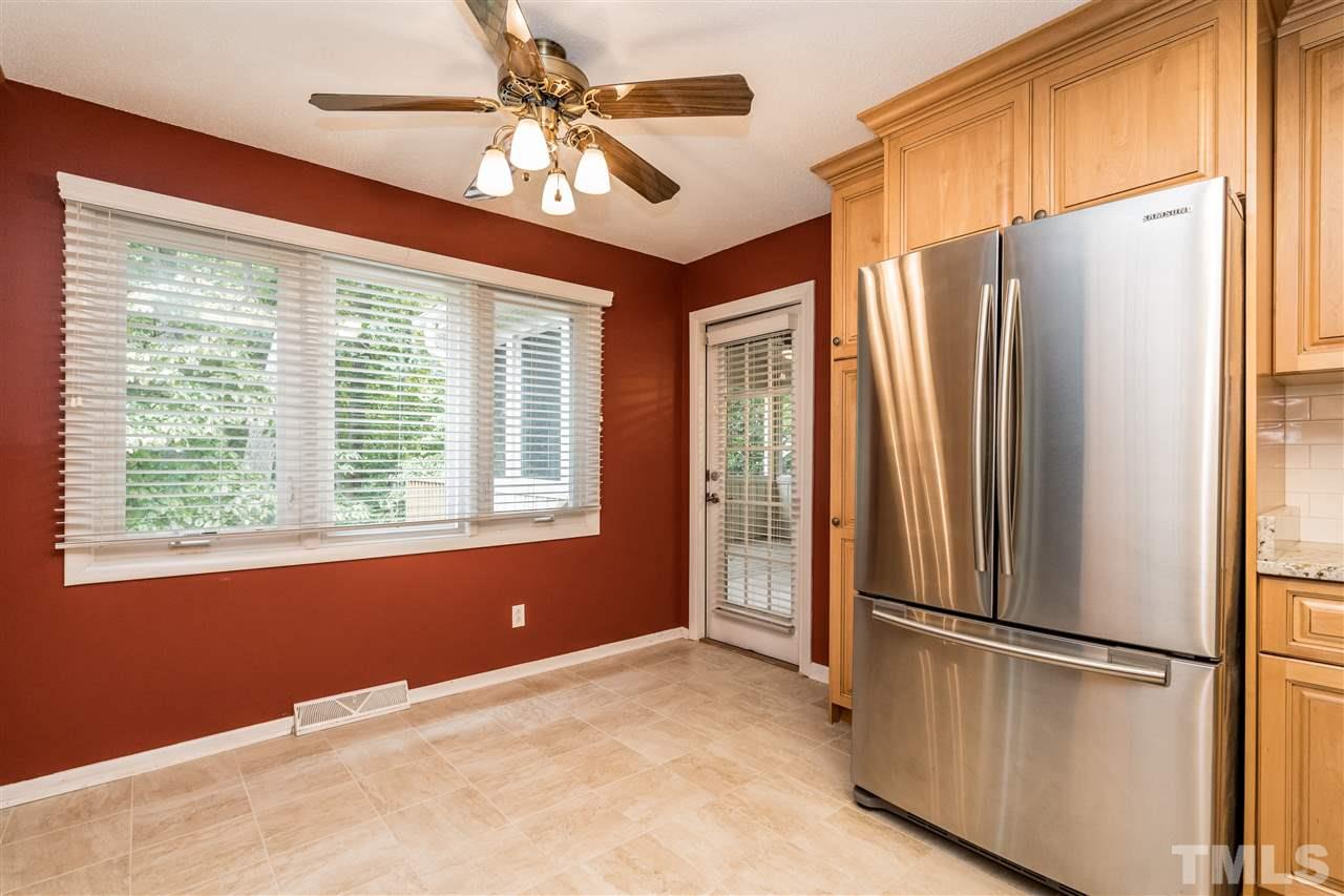 6704 Winding Trail Raleigh, NC 27612 - Photo 11 of 30 a view of a kitchen with a refrigerator ceiling fan and windows