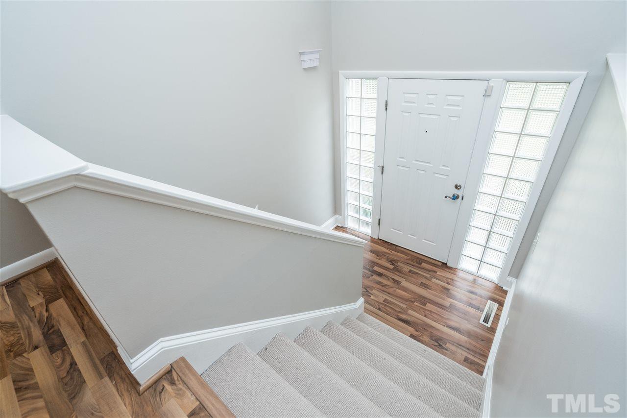 6704 Winding Trail Raleigh, NC 27612 - Photo 3 of 30 a view of an empty room with wooden floor and a window