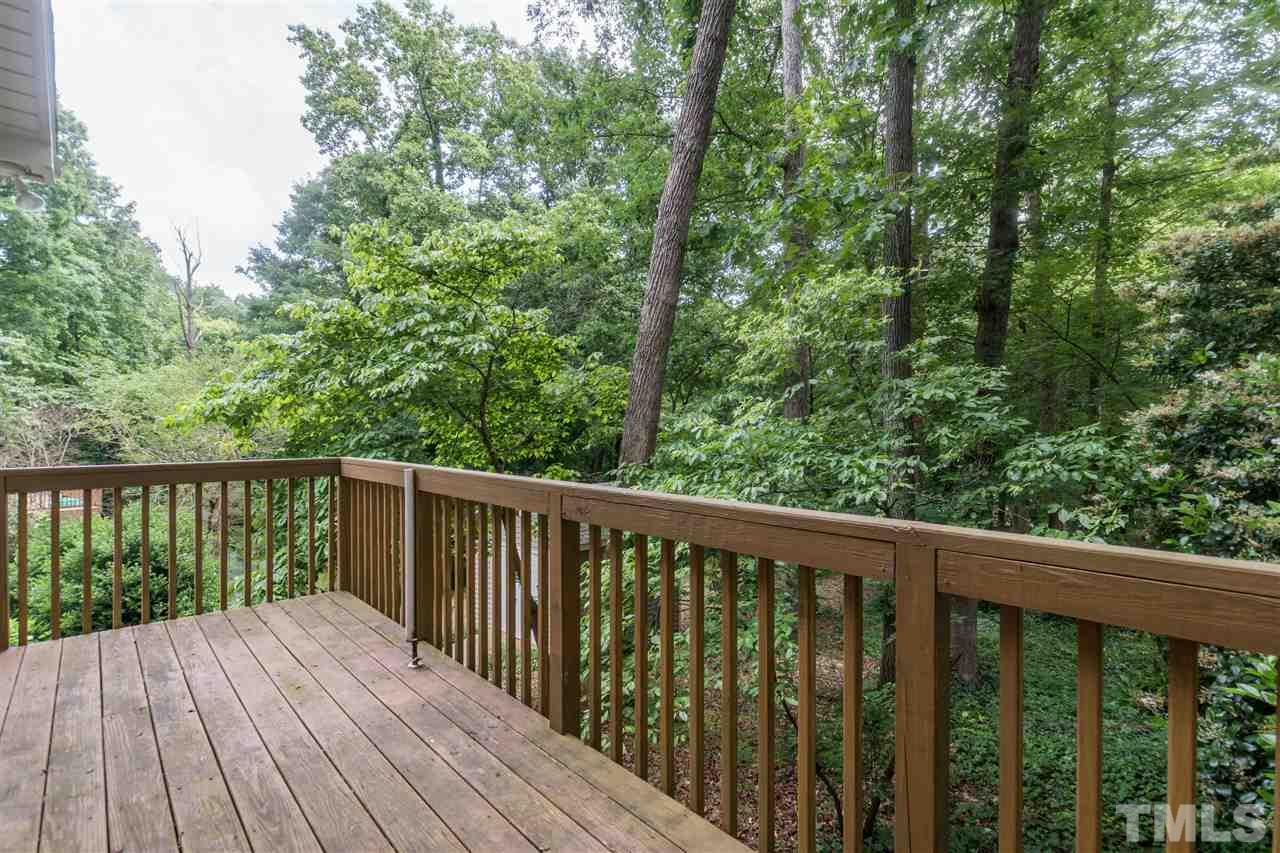 6704 Winding Trail Raleigh, NC 27612 - Photo 27 of 30 a balcony with wooden floor and trees in the back