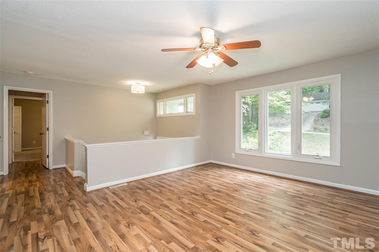 6704 Winding Trail Raleigh, NC 27612 - Photo 4 of 30 a view of an empty room with wooden floor and a window