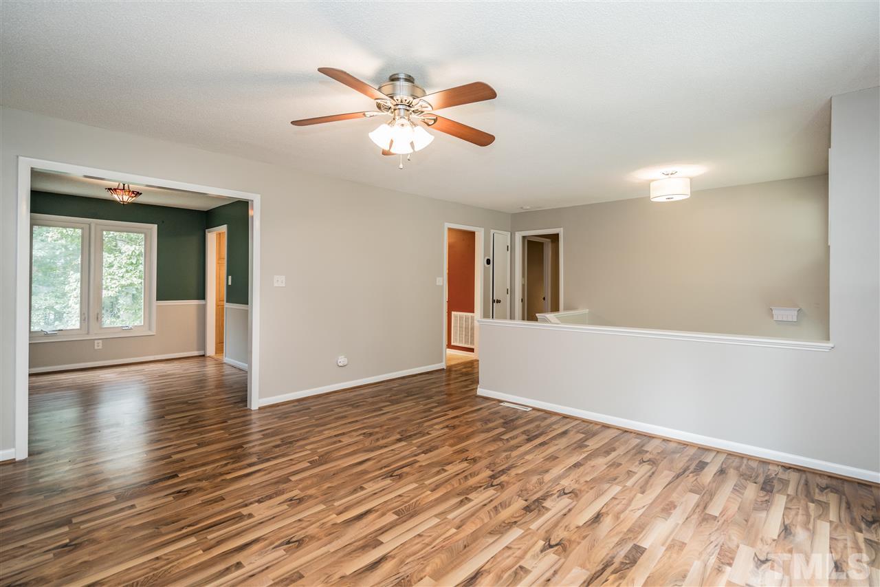 6704 Winding Trail Raleigh, NC 27612 - Photo 6 of 30 a view of an empty room with wooden floor and a window