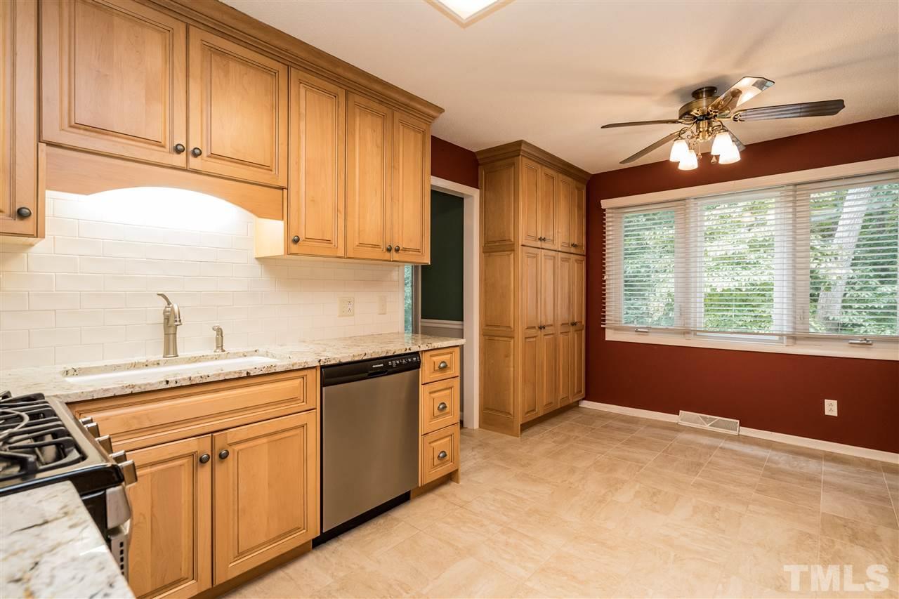 6704 Winding Trail Raleigh, NC 27612 - Photo 8 of 30 a kitchen with stainless steel appliances granite countertop a refrigerator a sink dishwasher a stove and white countertops with wooden floor