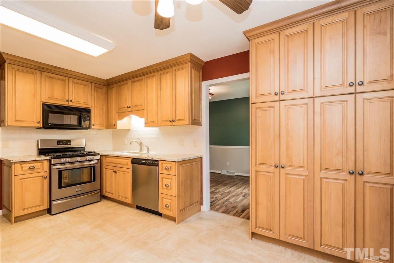 6704 Winding Trail Raleigh, NC 27612 - Photo 9 of 30 a kitchen with stainless steel appliances granite countertop a refrigerator a stove a sink and dishwasher with wooden floor
