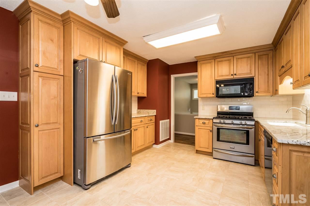 6704 Winding Trail Raleigh, NC 27612 - Photo 10 of 30 a kitchen with stainless steel appliances granite countertop a refrigerator stove and a sink