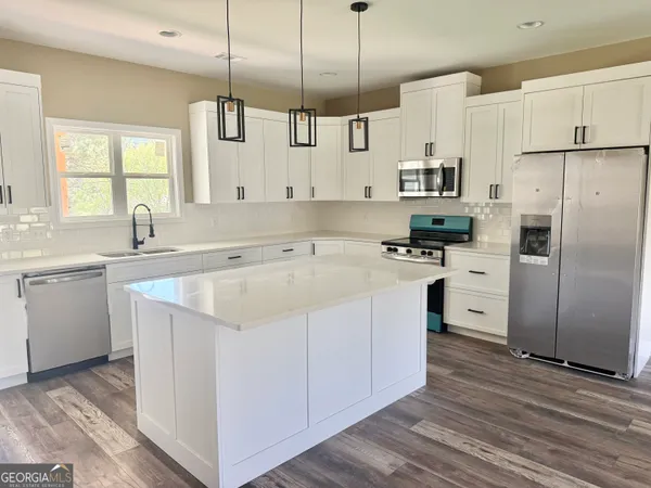 a kitchen with white cabinets sink and stainless steel appliances