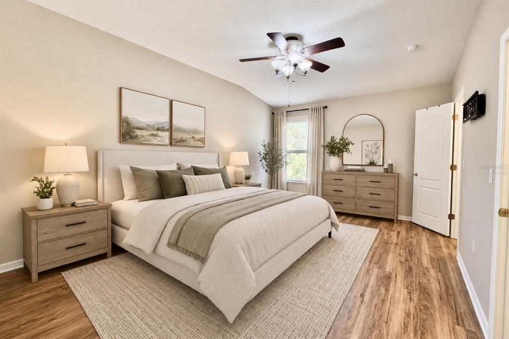 15609 Stable Run Drive Spring Hill, FL 34610 - Photo 17 of 37 a bedroom with a large bed and a chandelier