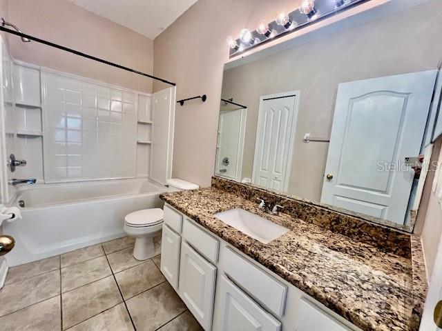 15609 Stable Run Drive Spring Hill, FL 34610 - Photo 22 of 37 a bathroom with a granite countertop sink a toilet a mirror and shower