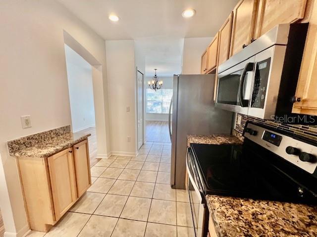 15609 Stable Run Drive Spring Hill, FL 34610 - Photo 10 of 37 a kitchen with stainless steel appliances granite countertop a refrigerator and a stove