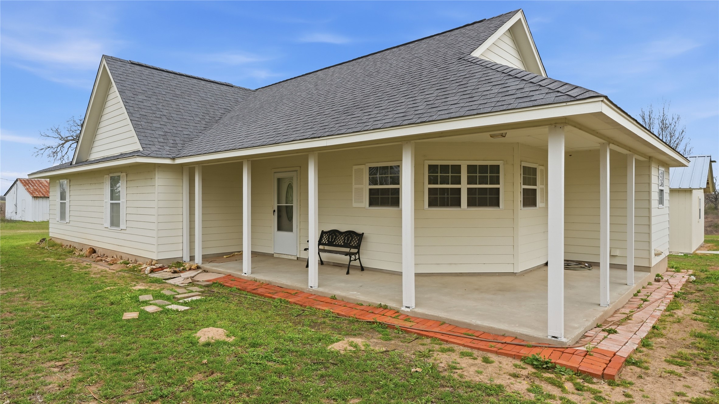 369 Young School House Road Smithville, TX 78957 - Photo 27 of 30 Back of house with roof with shingles, a yard, and covered porch