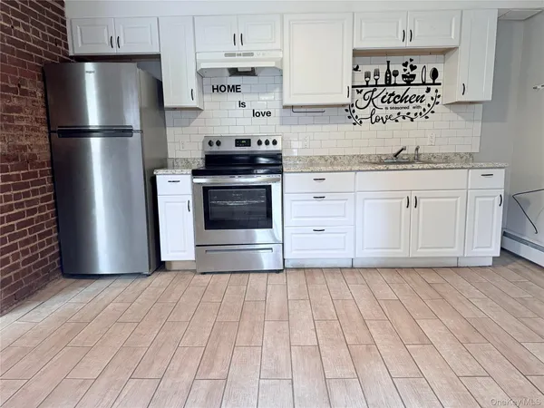 a kitchen with stainless steel appliances a refrigerator sink and cabinets