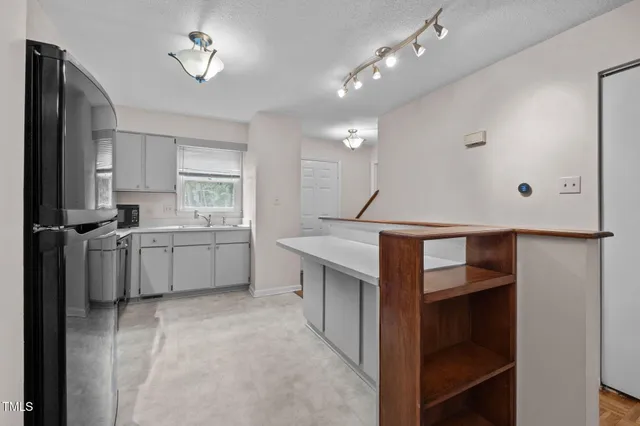 a kitchen with refrigerator and cabinets