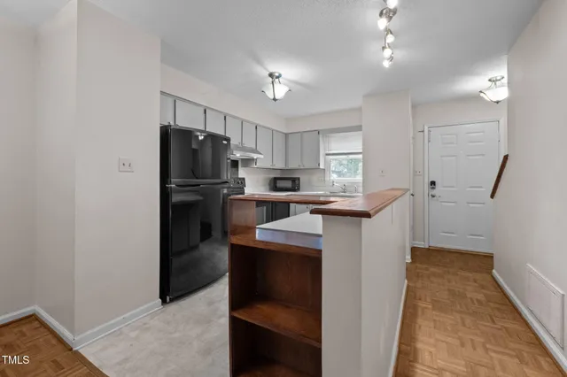 a kitchen with kitchen island a sink appliances and cabinets