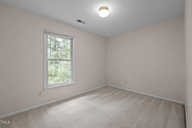an empty room with windows and view of closet