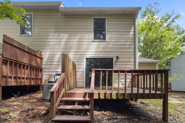 a view of a house with backyard and a wooden fence