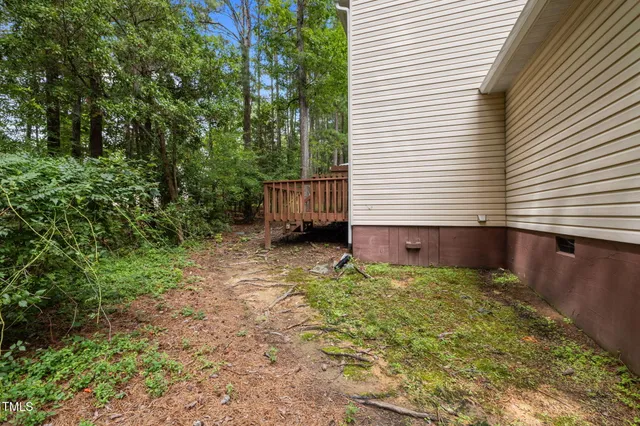 a balcony with wooden floor and yard in the back