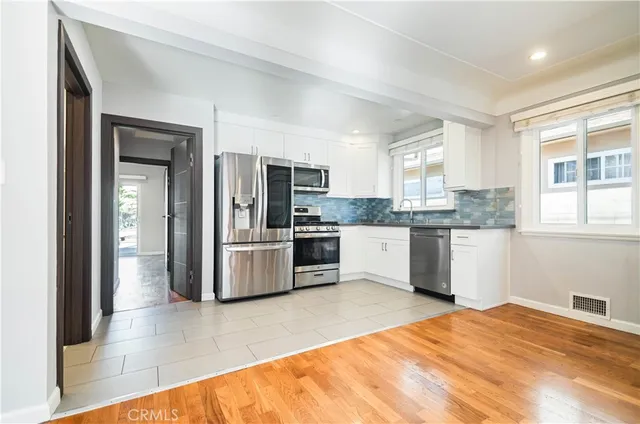 a kitchen with stainless steel appliances kitchen island granite countertop a refrigerator and cabinets