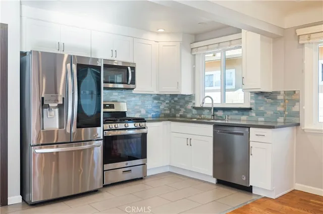 a kitchen with stainless steel appliances granite countertop a refrigerator stove and sink