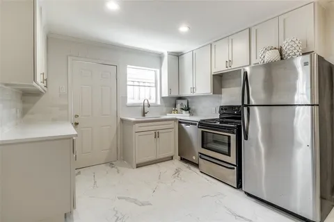 a kitchen with a refrigerator sink and cabinets