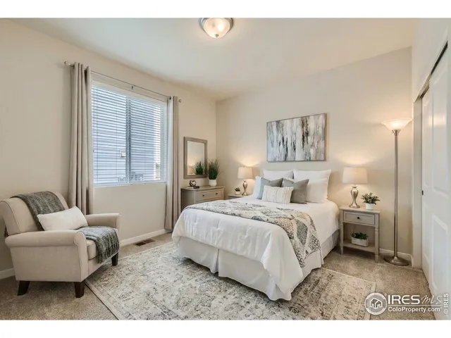 a bedroom with a bed lamp and a window