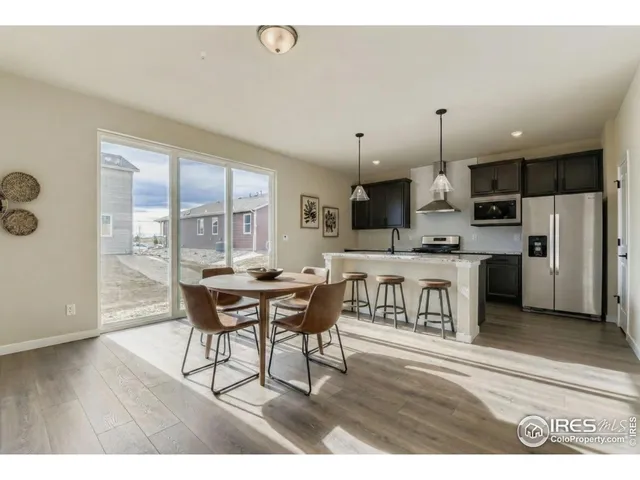 a open kitchen with a table chairs a sink dishwasher refrigerator and cabinets