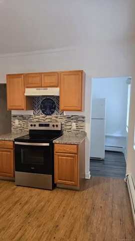 a kitchen with granite countertop a stove and a wooden floor