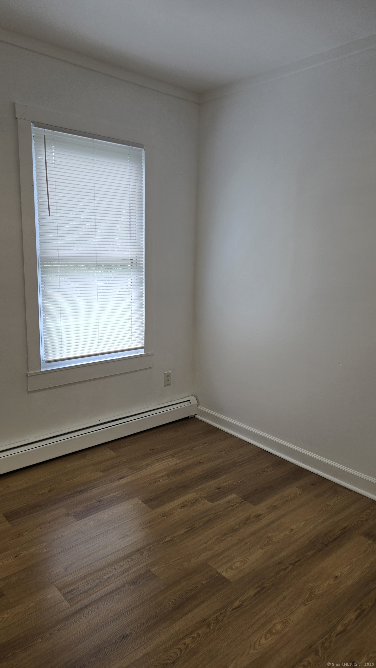 117 Dikeman Street Waterbury, CT 06704 - Photo 8 of 17 a view of an empty room with wooden floor and a window