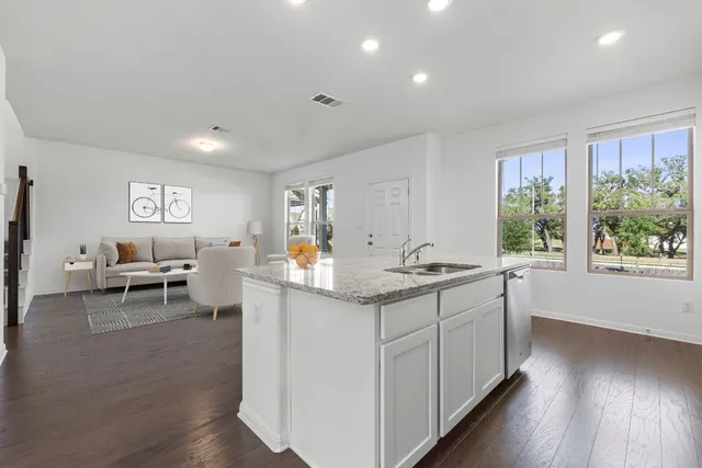 a kitchen with sink attached with living room