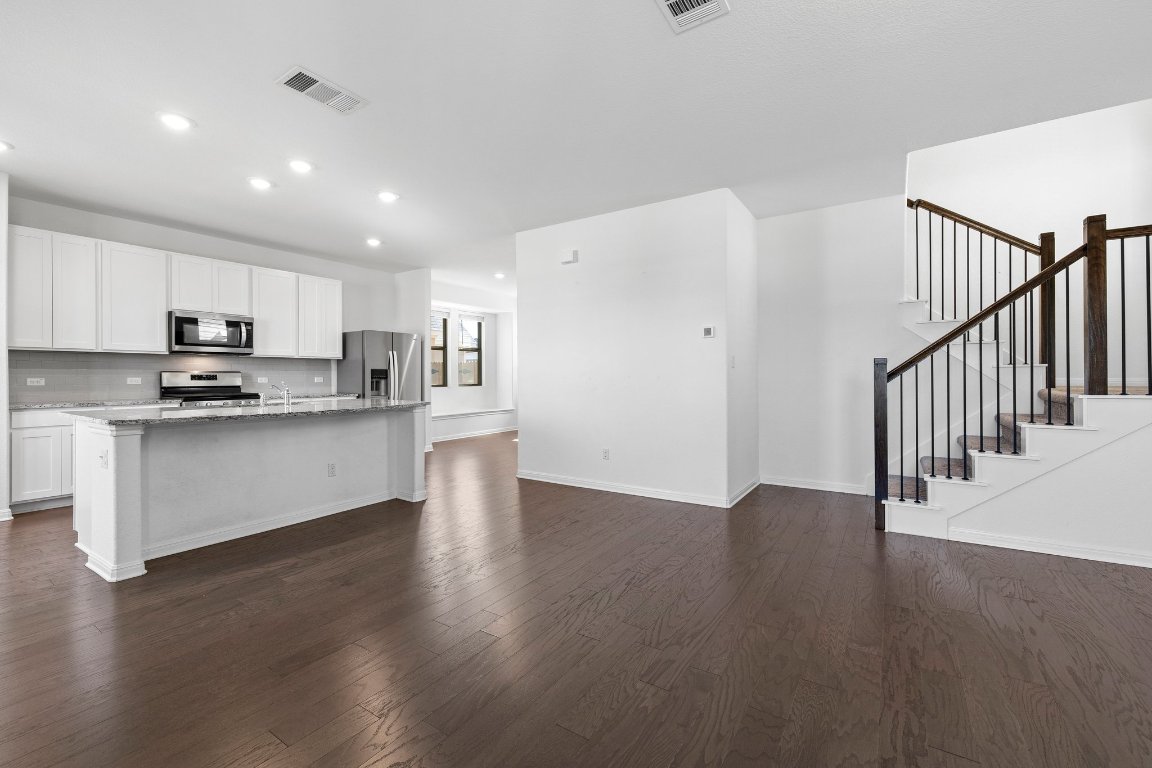 2429 Acoma Lane Leander, TX 78641 - Photo 20 of 39 a kitchen with stainless steel appliances granite countertop a refrigerator microwave and white cabinets