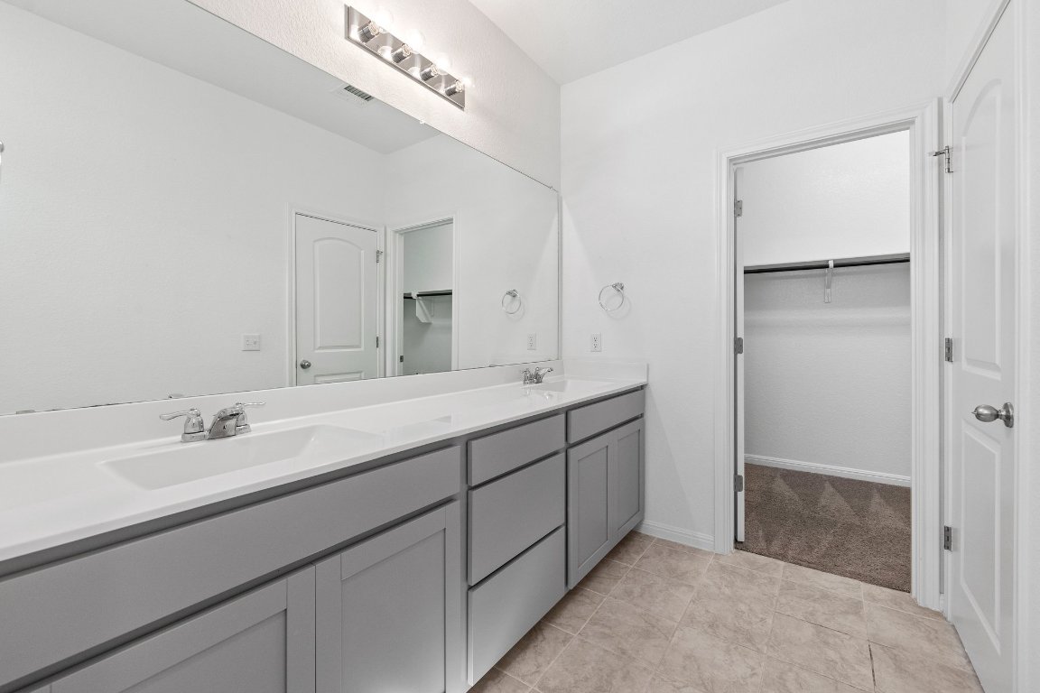 2429 Acoma Lane Leander, TX 78641 - Photo 32 of 39 a spacious bathroom with a double vanity sink and a mirror