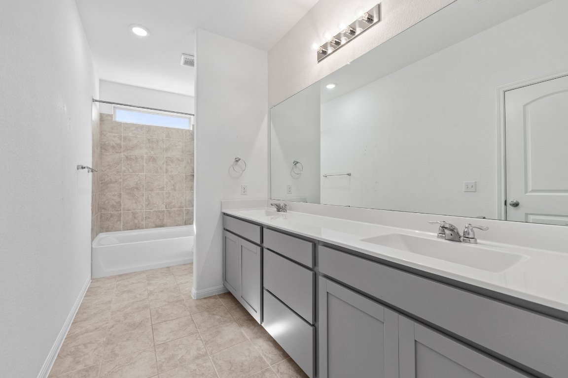2429 Acoma Lane Leander, TX 78641 - Photo 34 of 39 a spacious bathroom with a bathtub sink and mirror