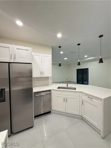 a kitchen with granite countertop white cabinets and black appliances