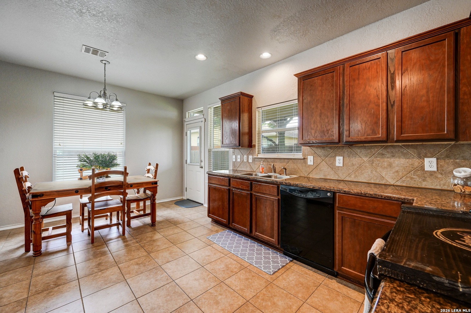 720 Hollow Ridge Schertz, TX 78108 - Photo 10 of 27 a kitchen with stainless steel appliances granite countertop wooden cabinets a dining table and chairs