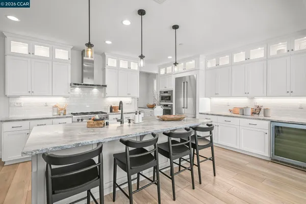 a kitchen with kitchen island granite countertop a table chairs sink and cabinets