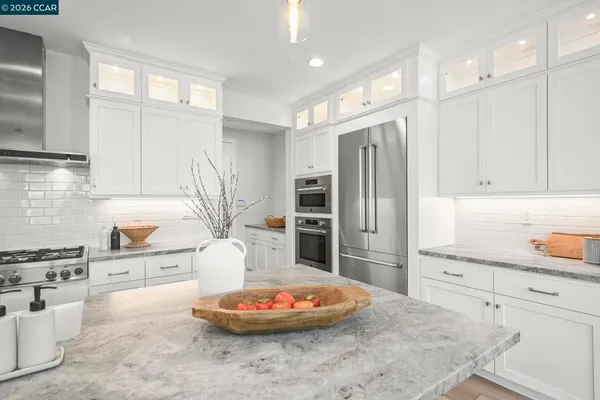a kitchen with stainless steel appliances granite countertop a refrigerator and a stove top oven
