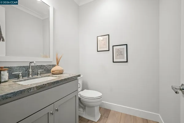 a bathroom with a granite countertop toilet sink and mirror
