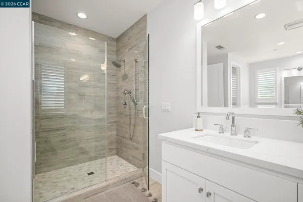 a bathroom with a shower sink and mirror