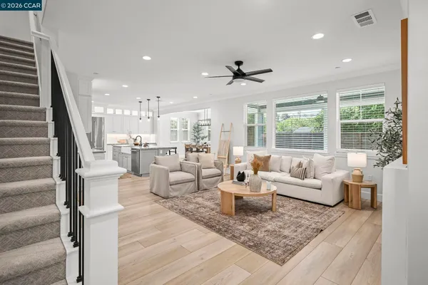 a living room with couches and a view of kitchen living room